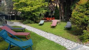 une rangée de chaises et de tables colorées sur l'herbe dans l'établissement Casa Emilia, à Dongo