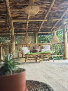 eine Bank auf einer Veranda mit einem Holzdach in der Unterkunft Arawe Retreat in Ella