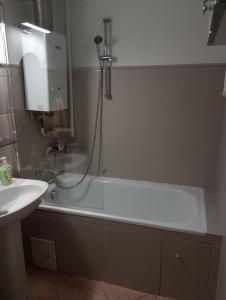 La salle de bains est pourvue d'une baignoire et d'un lavabo. dans l'établissement Apartament na Łazarzu, à Poznań