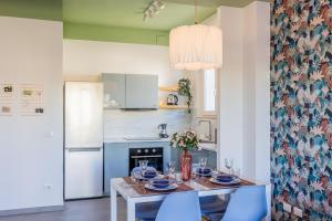 uma cozinha com uma mesa de jantar e cadeiras azuis em Chez Monique em Oleggio Castello