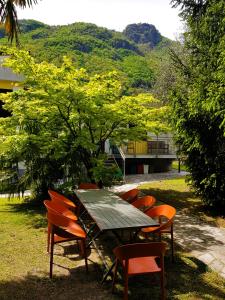 une table de pique-nique et des chaises dans l'herbe avec un arbre dans l'établissement Casa Emilia, à Dongo