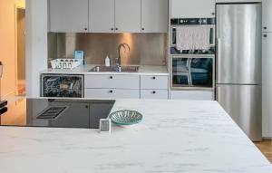 uma cozinha com armários brancos e um balcão branco em Beautiful Home In rebro With Kitchen em Örebro