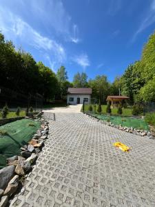 a cobblestone path in a yard with a house at Domek w lesie Sauna i Gorąca balia Wellness&Spa in Grybów