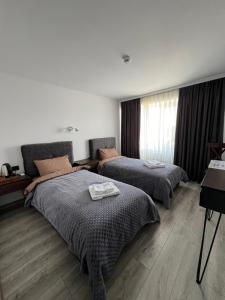 Habitación de hotel con 2 camas y ventana en Mayster Home, en Chernivtsi