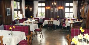 a restaurant with white tables and chairs and windows at Hotel Restaurant Engel in Pfaffenweiler