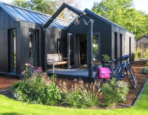 un cobertizo negro con una bicicleta estacionada en el patio en Lagom I Tiny House en Epe