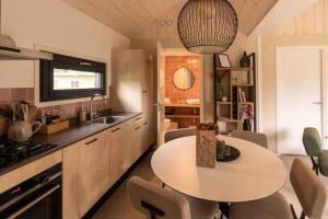 a kitchen with a table with chairs and a sink at Lagom I Tiny House in Epe