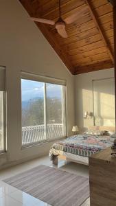 une chambre avec un lit et une grande fenêtre dans l'établissement Swiss Cottage Bhurban, à Bhurban 15 autres photos