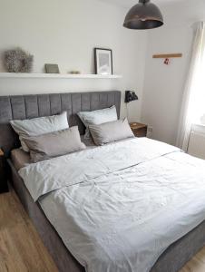 een slaapkamer met een groot bed met witte lakens en kussens bij Ferienwohnung Deichblick in Tönning
