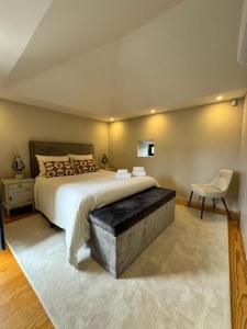 1 dormitorio con 1 cama grande y 1 silla en GuestReady - An Amazing Retreat in Várzea do Douro, en Marco de Canaveses