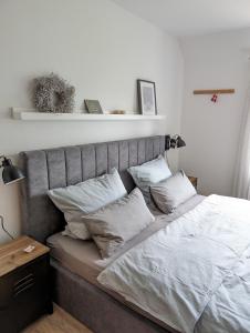 テニングにあるFerienwohnung Deichblickのベッドルーム1室(白いシーツと枕のベッド1台付)