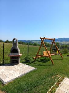 a playground with a grill and a swing at Domek na Hubce II in Maniowy