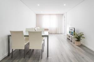 a dining room with a table and white chairs at GuestReady - Casegas residence in Marquês in Porto +16 photos