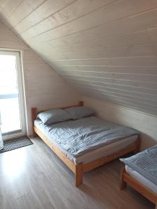 sypialnia z łóżkiem na poddaszu w obiekcie Anetta Domki Mielno w mieście Mielno