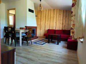 salon z czerwoną kanapą i stołem w obiekcie Pensjonat Sawica w mieście Szczytno