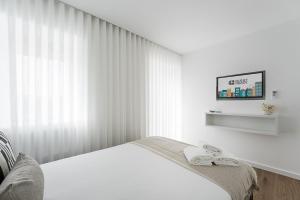 ein weißes Schlafzimmer mit einem Bett und einem Fenster in der Unterkunft GuestReady - Villa Stay Luxury Property in Anais