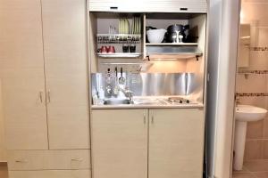 a kitchen with white cabinets and a sink at GREEK PRIDE PANTHEA STUDIOS in Skala Fourkas