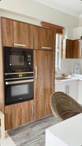 cocina con armarios de madera y microondas en Swiss Cottage Bhurban, en Bhurban