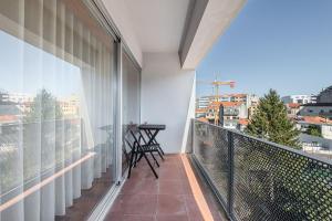 a balcony with a table and a view of a city at GuestReady - Go To Sleep in Porto