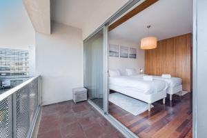 a bedroom with a white bed and a balcony at GuestReady - Go To Sleep in Porto