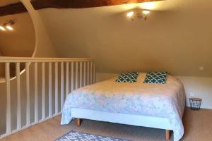 een slaapkamer met een bed met blauwe kussens erop bij La Chaumière de Mano in Berville-sur-Mer