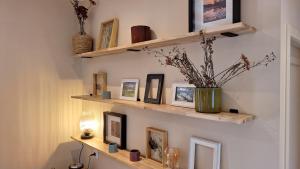 um quarto com prateleiras de madeira na parede com fotografias em Les Galapons em Trept