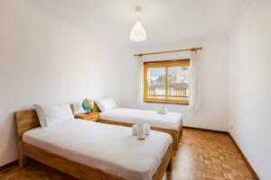 dwa łóżka w pokoju z oknem w obiekcie GuestReady - Exclusive Retreat in Lavra w mieście Lavra