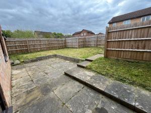 a backyard with a wooden fence and a yard at Homely Milton Keynes Stay! in Milton Keynes
