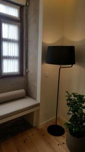 una stanza con una lampada e una finestra con una panca di GuestReady - Catorze de Outubro Houses 423 a Vila Nova de Gaia