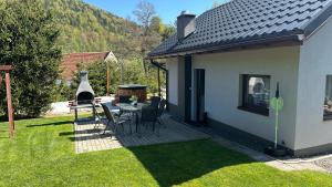 eine Terrasse mit einem Tisch und Stühlen im Hof in der Unterkunft Domek Adusiówka in Stronie Śląskie