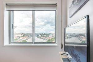 a room with a window with a view of a river at GuestReady - Porto Fantastic View in Vila Nova de Gaia