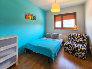 a small bedroom with a bed and a chair at Visit Baltic - Platan II in Świnoujście