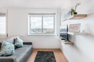 a living room with a couch and a window at GuestReady - Porto Fantastic View in Vila Nova de Gaia