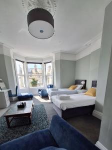 - un salon avec deux lits et un canapé dans l'établissement No 27 Chapel Street Guest House, à Llandudno