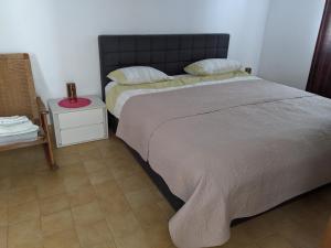 a bedroom with a large bed and a side table at Emilija Apartments Privlaka in Privlaka