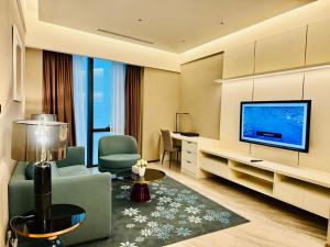 a living room with a couch and a television at Imperial lexis KLCC By AR Hospitality in Kuala Lumpur