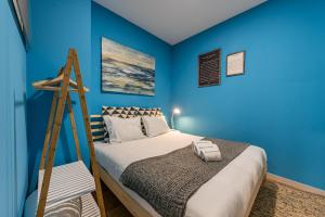 a bedroom with blue walls and a bed with a ladder at GuestReady - Miragaia Historical Sight in Porto