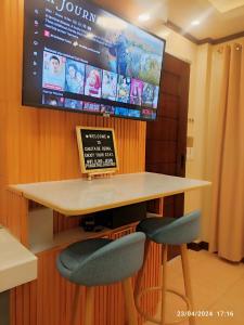 - une télévision murale avec une table et deux chaises dans l'établissement Casita de Reina Staycation House - A cozy 1-Bedroom condo-style house, à Locsin