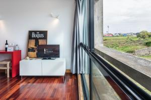 Cette chambre dispose d'une fenêtre et d'un bureau blanc avec un moniteur. dans l'établissement GuestReady - Zarco Studio, à Leça da Palmeira