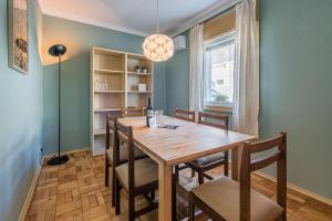 a dining room with a wooden table and chairs at GuestReady - City & Beach Garden Home in Porto