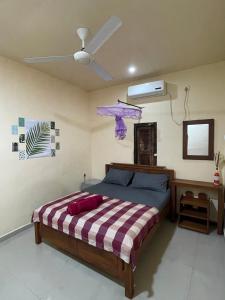 una camera con letto e ventilatore a soffitto di Romance in Bey ad Arugam