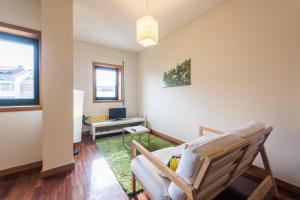 ein Wohnzimmer mit einem Stuhl und einem TV in der Unterkunft GuestReady - Even Flow Flat in Porto