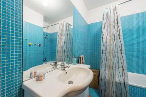 ein blau gefliestes Bad mit einem Waschbecken und einer Dusche in der Unterkunft GuestReady - Even Flow Flat in Porto