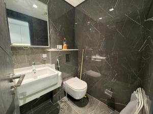 a bathroom with a white sink and a toilet at Furnished studio استديو مفروش studio city in Dubai
