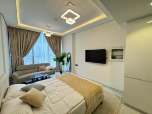 - une chambre avec un lit et une télévision murale dans l'établissement Furnished studio استديو مفروش studio city, à Dubaï