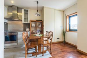 una cucina con tavolo e sedie in legno di GuestReady - Even Flow Flat a Porto