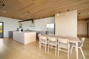 eine Küche mit einem Tisch und Stühlen sowie einem Kühlschrank in der Unterkunft Amazing View - 5 bedrooms - new house - modern and exclusive in Bergen