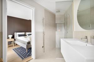 a bathroom with a sink and a shower and a bed at Amazing View - 5 bedrooms - new house - modern and exclusive in Bergen