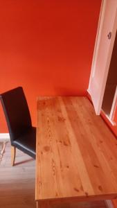 een houten tafel en een zwarte stoel in een kamer bij L'Auberge in Londen