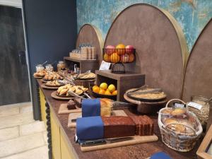 un buffet con pan y otros alimentos en una mesa en ibis Styles Dijon Sud Domaine De Beauregard 21600 Longvic en Dijon
